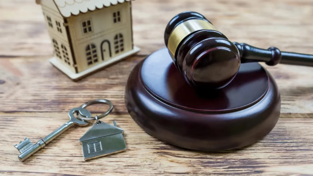 Llaves de una vivienda sobre una mesa y un mazo de juez para ilustrar la Ley de Segunda Oportunidad
